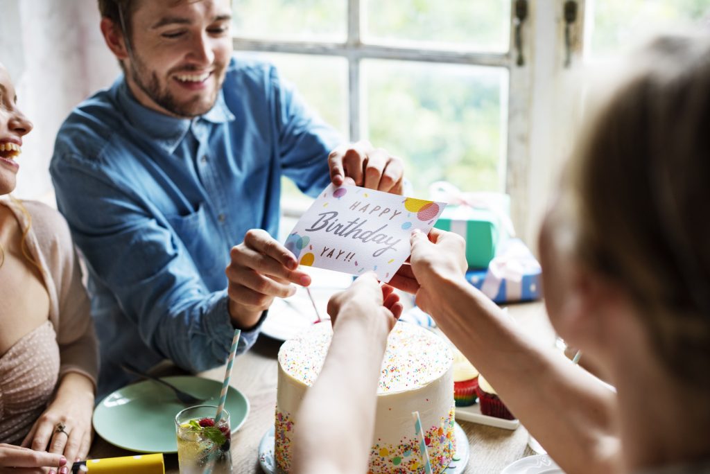 Man Giving Birthday Wishing Card to Friend